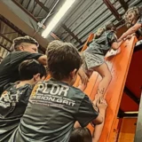 Kids help each other climb an indoor obstacle wall during one of Mission Grit kids team building events in Charlotte NC.