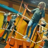 Girl balances across an indoor obstacle course while other kids complete challenges in after school programs in Charlotte NC.