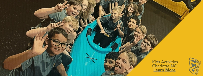 Children gathered around a kayak during a Mission Grit teamwork activity that builds confidence and collaboration.