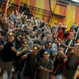 Large group of children celebrating after completing a Mission Grit youth leadership and obstacle course program.