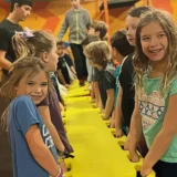 Children working together during a Mission Grit obstacle course birthday party that encourages teamwork and fun.