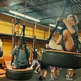 Children enjoying tire swing obstacles during a Mission Grit kids fitness class in Charlotte and Fort Mill.