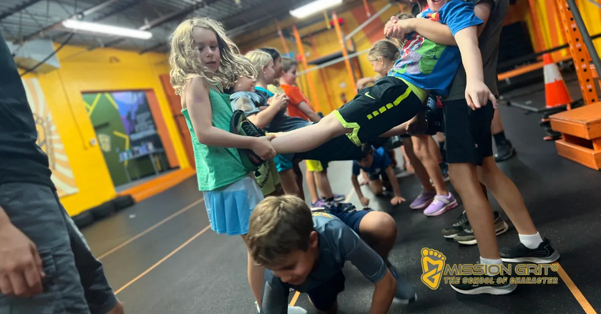 Children working together in a Mission Grit teamwork challenge that builds communication, trust, and problem-solving skills.